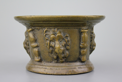 A bronze mortar with lion's heads and 3 various pestles, 17th C.